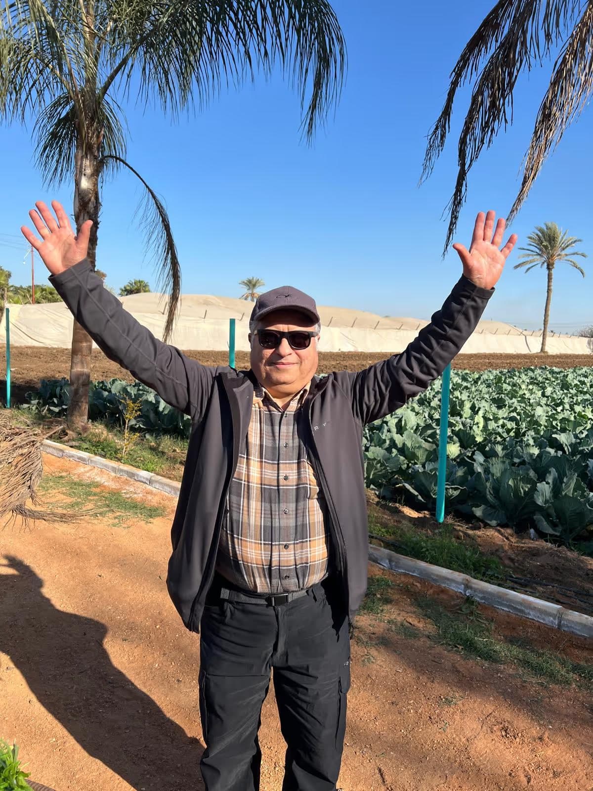 A warm welcome to Mansouria Retreat — a dear friend of the family raising his arms among the lettuce rows and palms